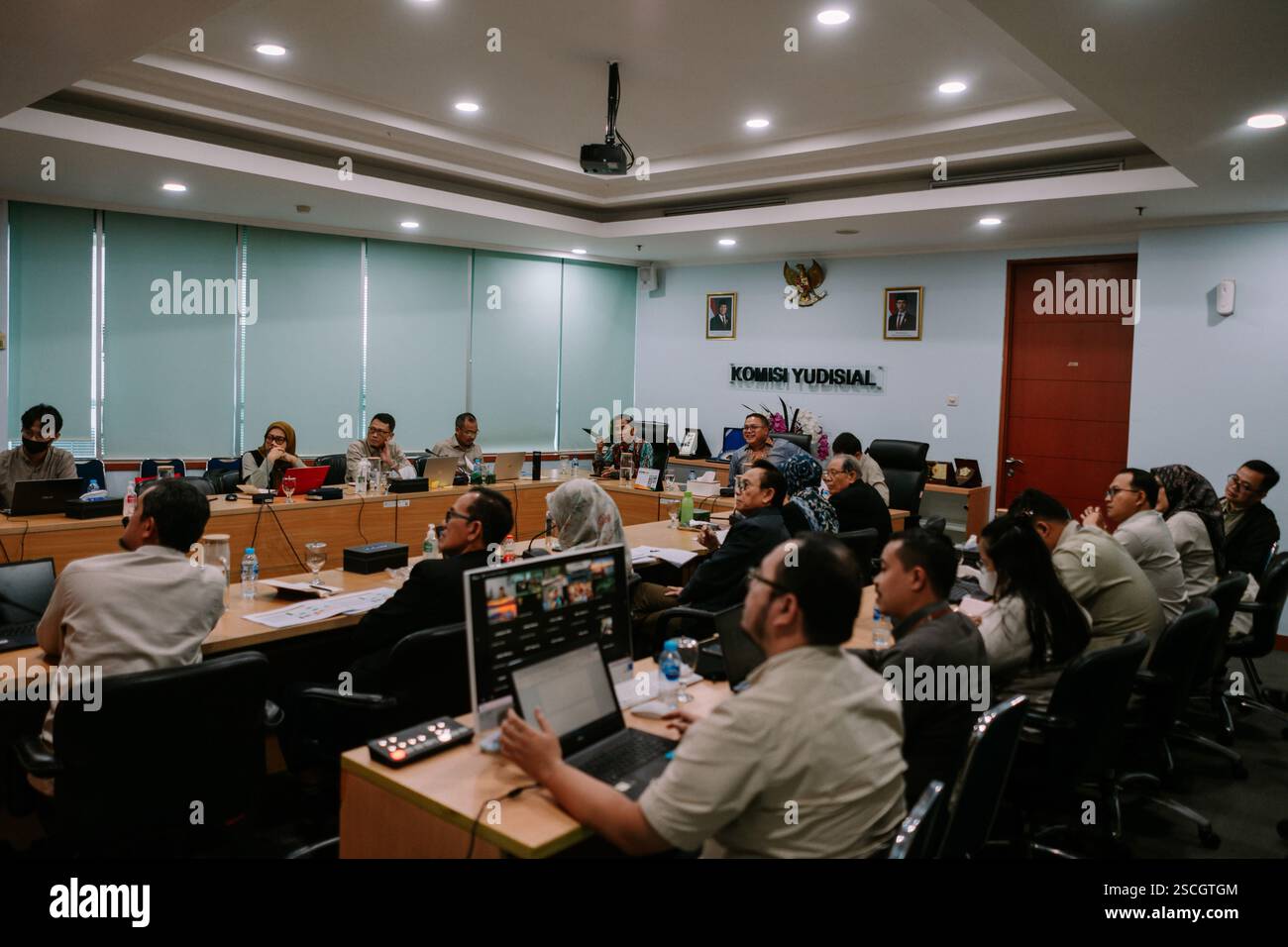 Jakarta, 6. Februar 2025. Gruppe von Personen, die an einer Besprechung in einem formellen Konferenzraum teilnehmen und sich auf eine Präsentation konzentrieren. Stockfoto