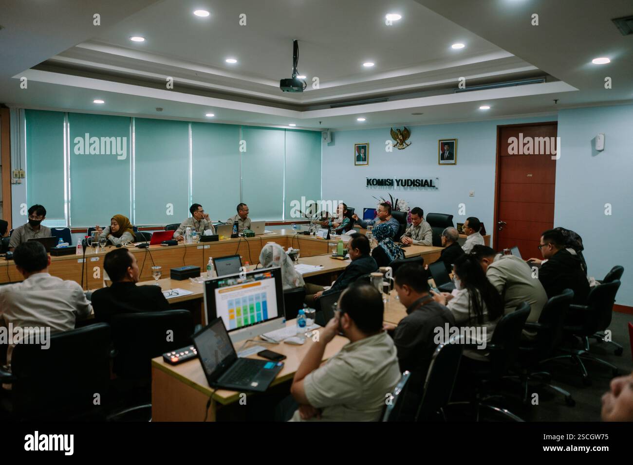Jakarta, 6. Februar 2025. Gruppe von Personen, die an einer Besprechung in einem formellen Konferenzraum teilnehmen und sich auf eine Präsentation konzentrieren. Stockfoto