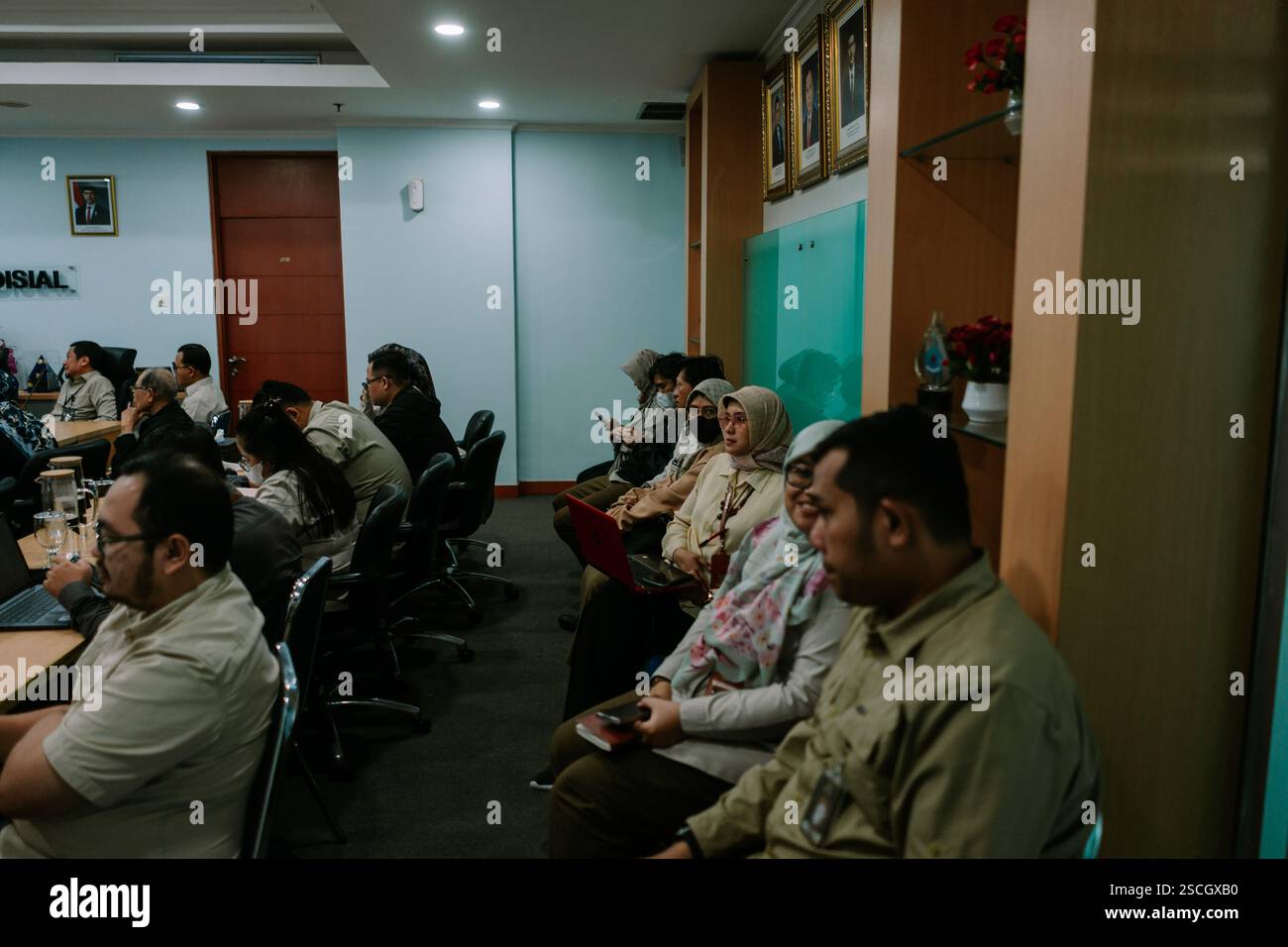 Jakarta, 6. Februar 2025. Gruppe von Personen, die an einer Besprechung in einem formellen Konferenzraum teilnehmen und sich auf eine Präsentation konzentrieren. Stockfoto