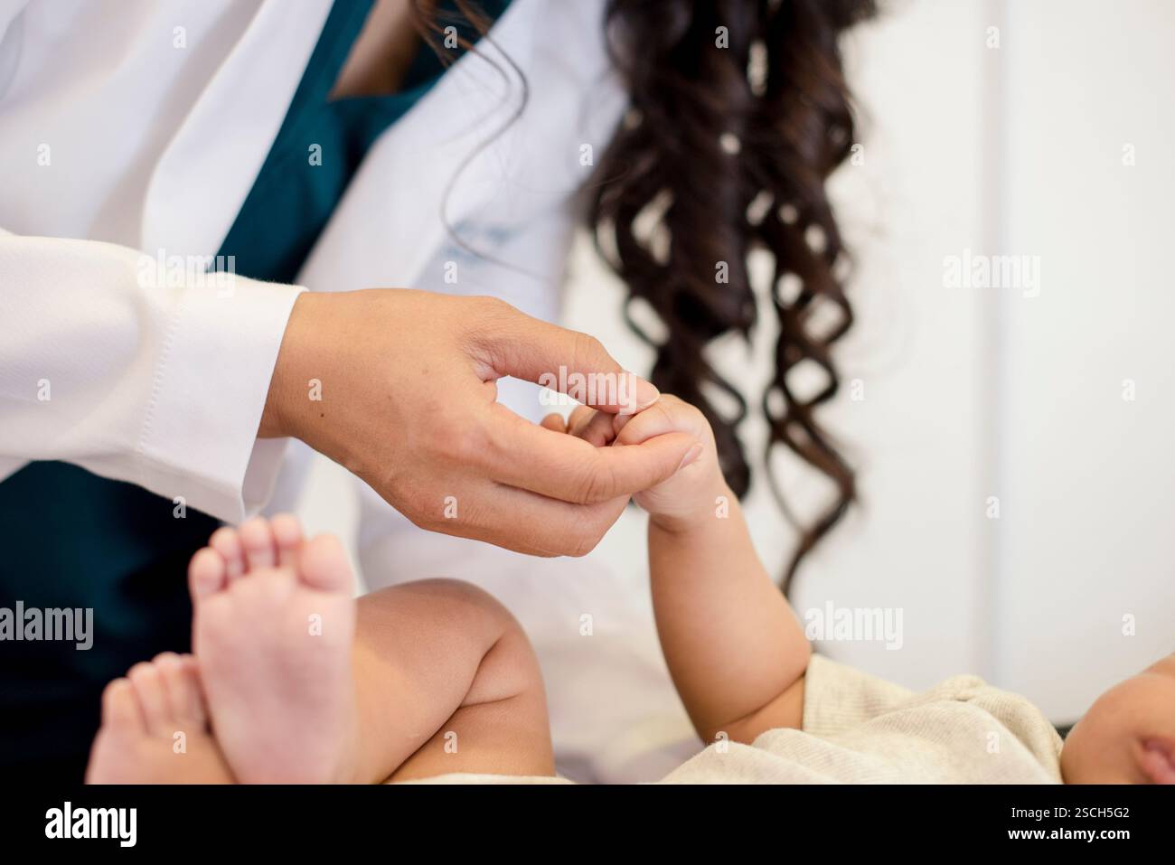 Nahaufnahme eines Babys, das die Hand des Arztes hält Stockfoto