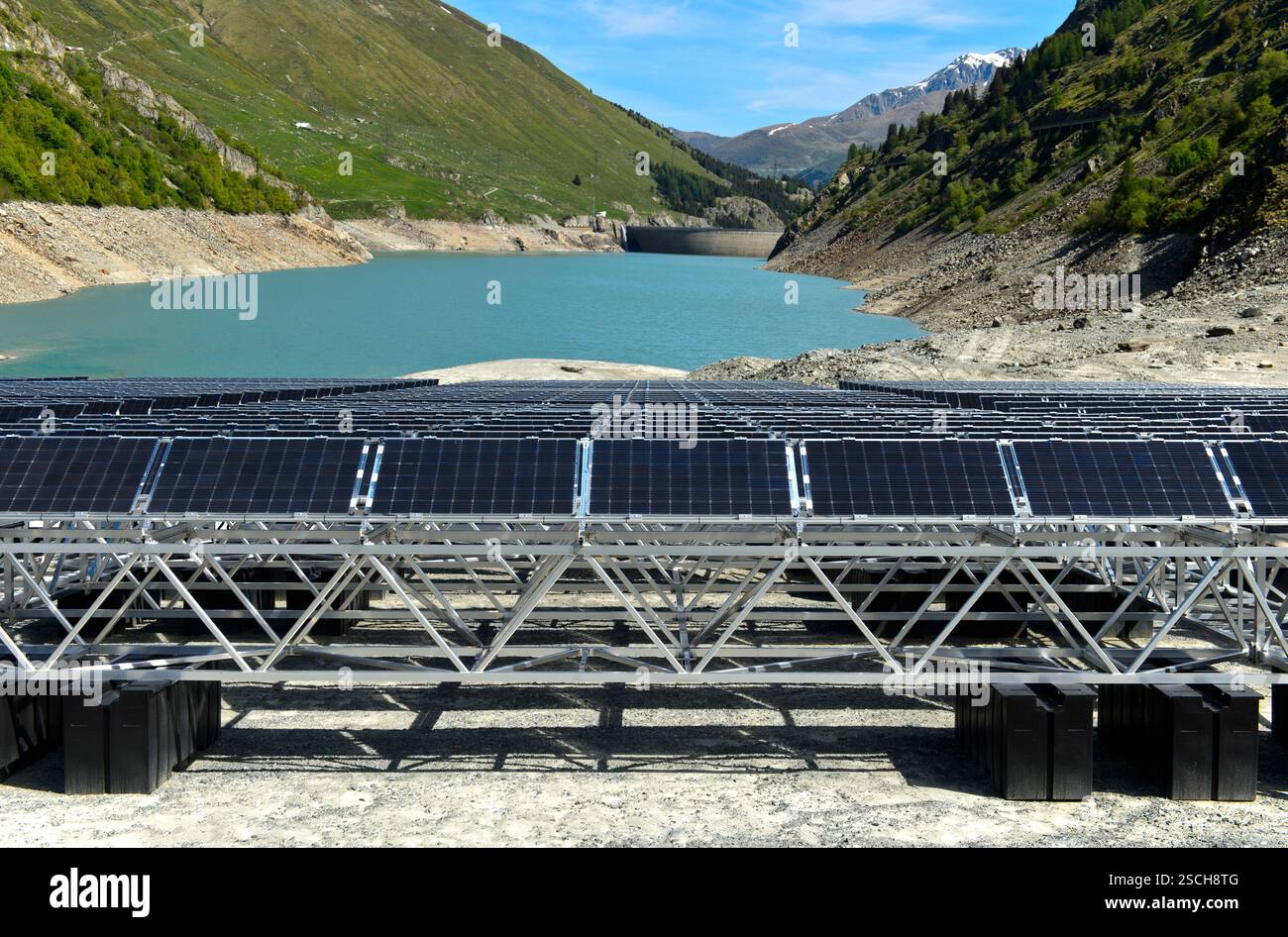 Solarpaneele des ersten schwimmenden alpinen Solarkraftwerks liegen bei Ebbe am Ufer des Stausees Lac des Toules im Wallis Stockfoto