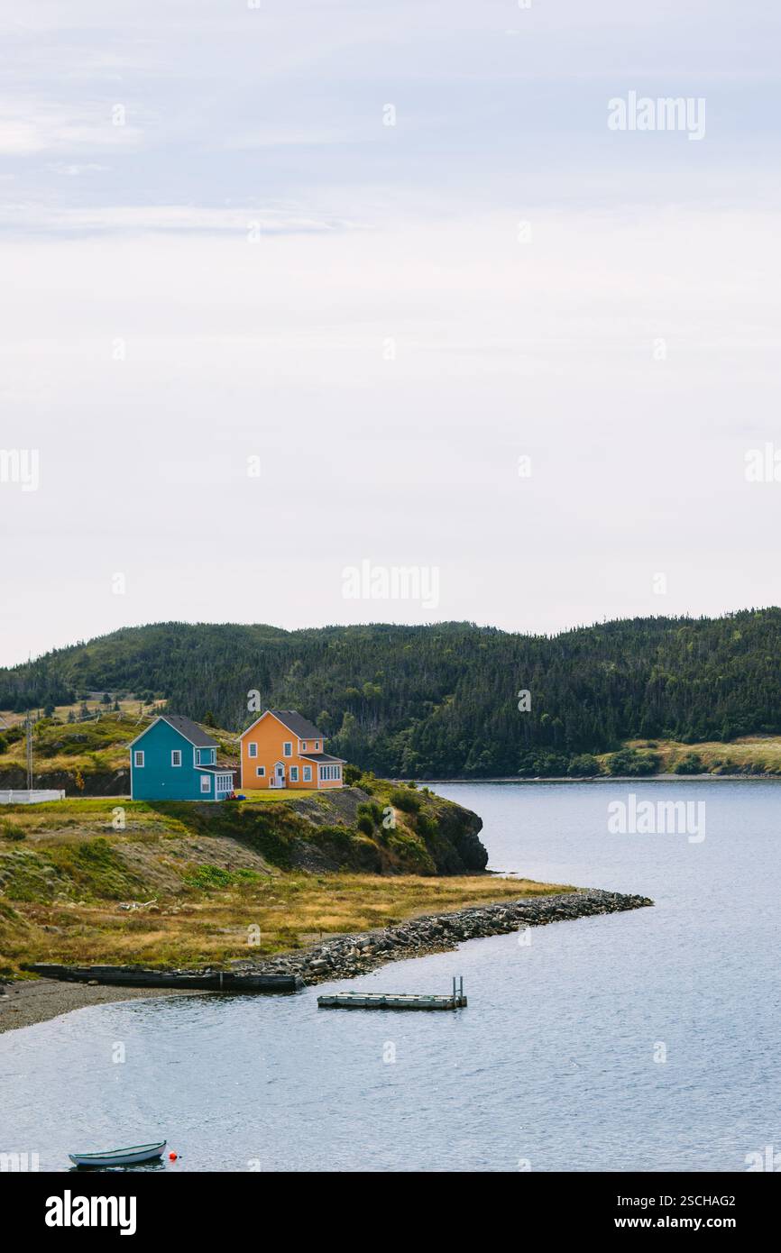 Blick auf die Küste von Trinity, Neufundland und Labrador, Kanada, mit lebhaften Häusern am Wasser unter bewölktem Himmel. Die ruhige Lage am Meer ist ein Fang Stockfoto