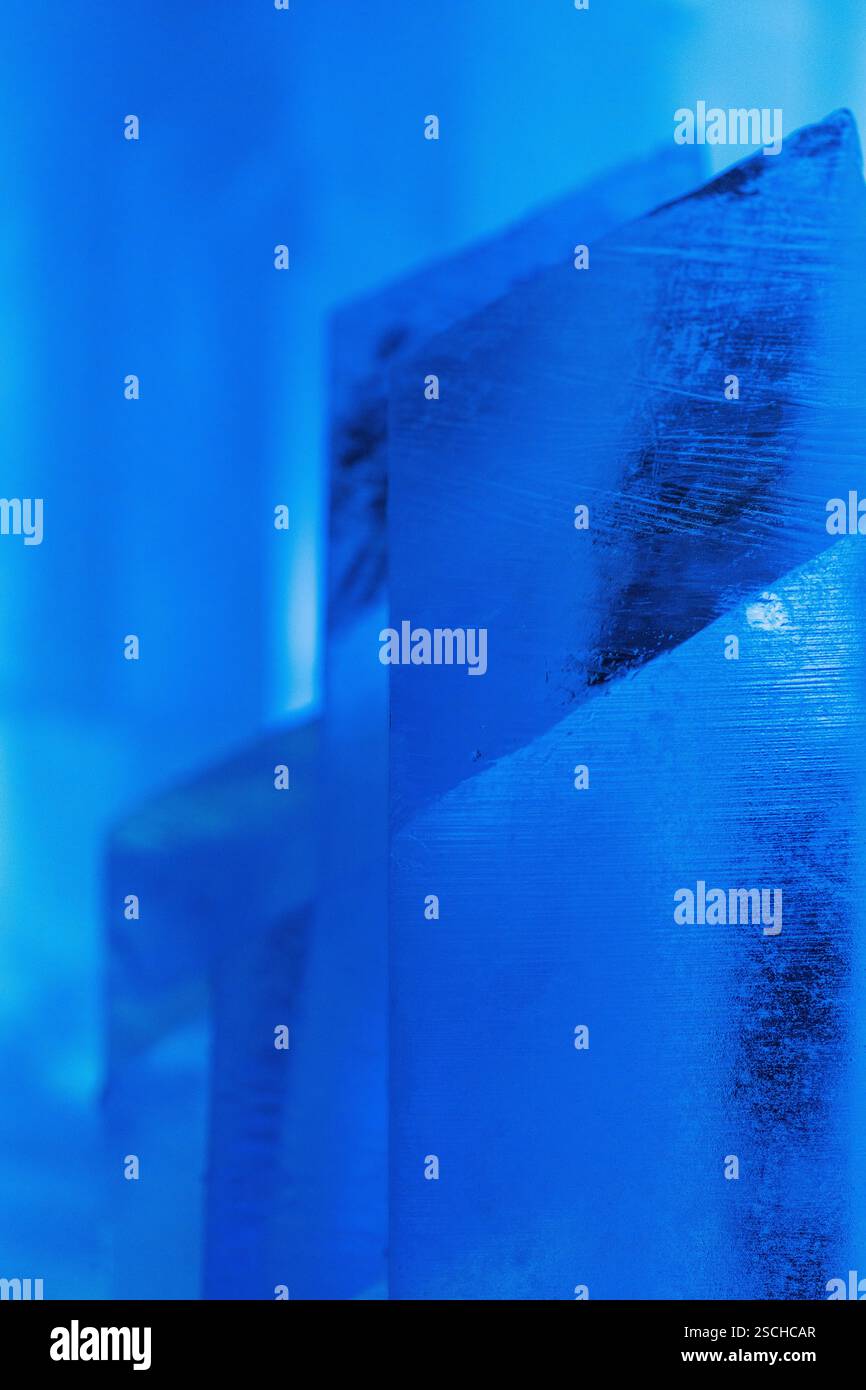 Nahaufnahme von aufwändig geformten Eiskonstruktionen, die in einem temporären Eishotel in Schwedisch Lappland mit einem kühlen blauen Leuchten beleuchtet werden, um das ruhige Beau einzufangen Stockfoto