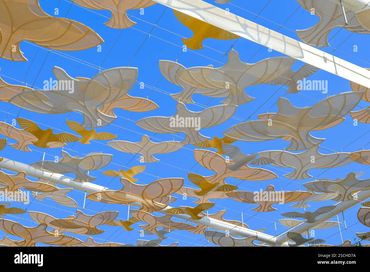 Clevere Verwendung von Sonnenschirmen, um die Sommerhitze in Dubai zu reduzieren. Diese verwenden sich wiederholende fliegende Vögel als elegantes Muster, um die Sonne herauszufiltern. Stockfoto