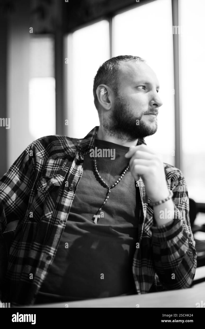 Ein netter und stilvoller Mann sitzt in einem Café, nachdenklich. Stockfoto