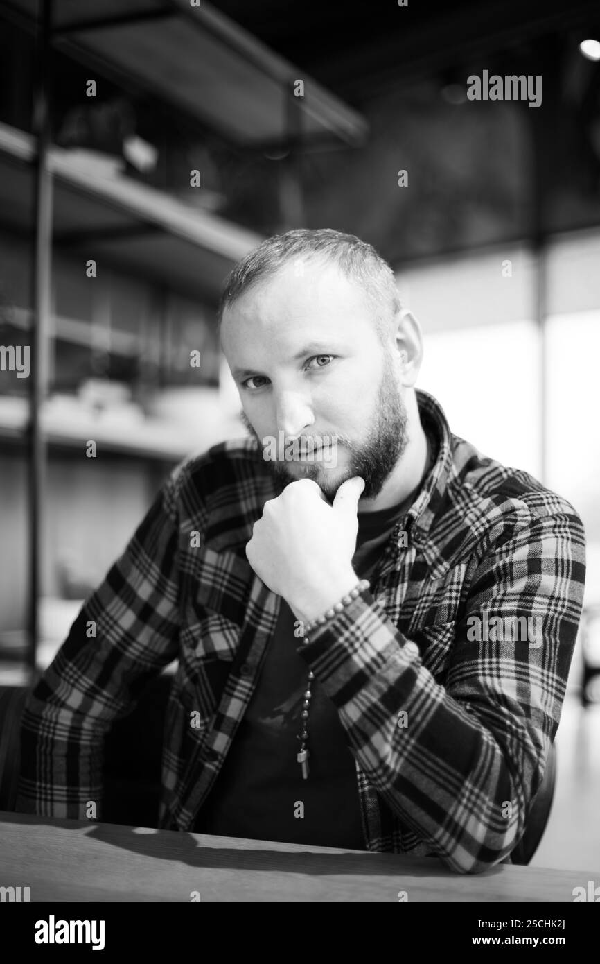 Ein netter und stilvoller Mann sitzt in einem Café, nachdenklich. Stockfoto