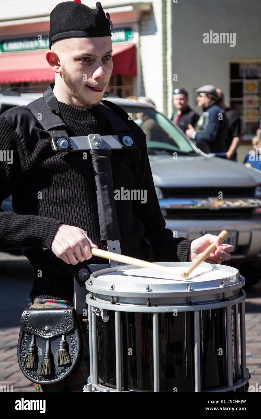 Ein Piper spielt eine Trommel. Musiker, der eine Snare-Trommel in einer Parade spielt. Stockfoto