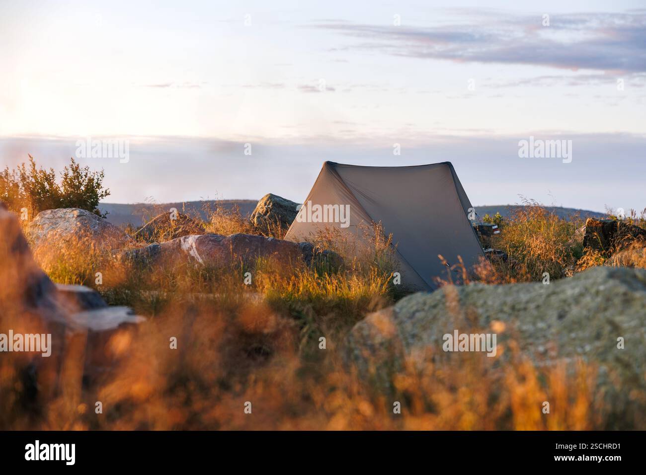 Ultraleichtes Zelt für Alleinreisen. Wildes Camping am Berggipfel während der Wanderung in der Natur. Outdoor-Abenteuer Stockfoto