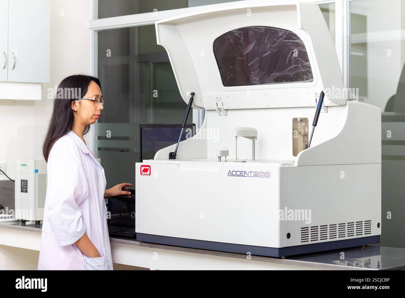 A female medical technician operates medical equipment at a local clinic in Baguio City, Philippines providing essential community health services Stockfoto