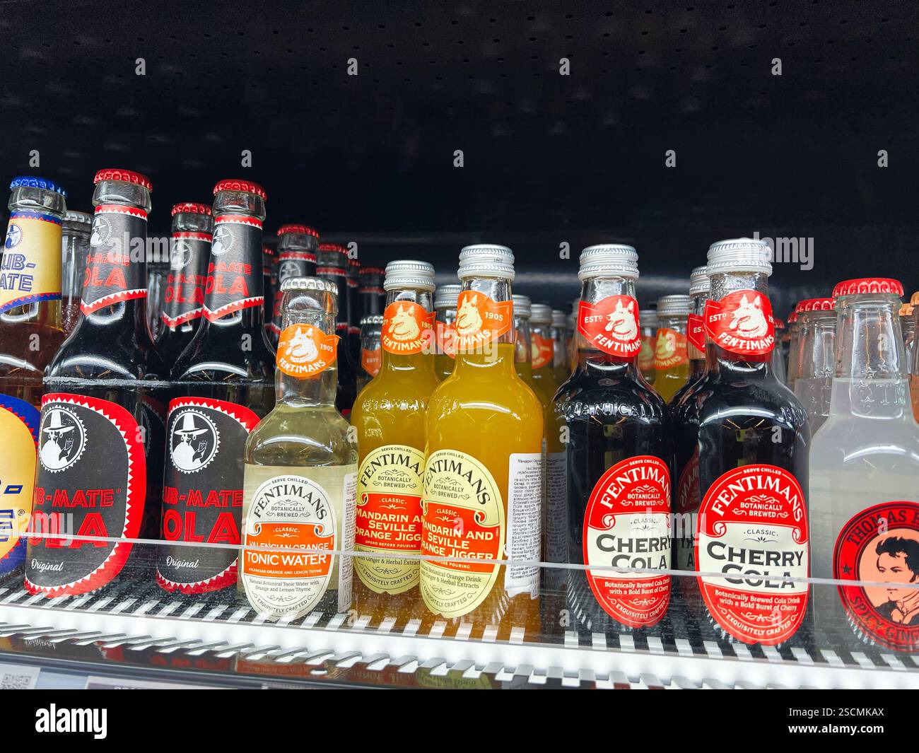 Kiew, Ukraine - 04. Februar 2025: Verschiedene Getränke, darunter Cola und Tonic Water, werden in Glasflaschen auf Regalen ausgestellt Stockfoto
