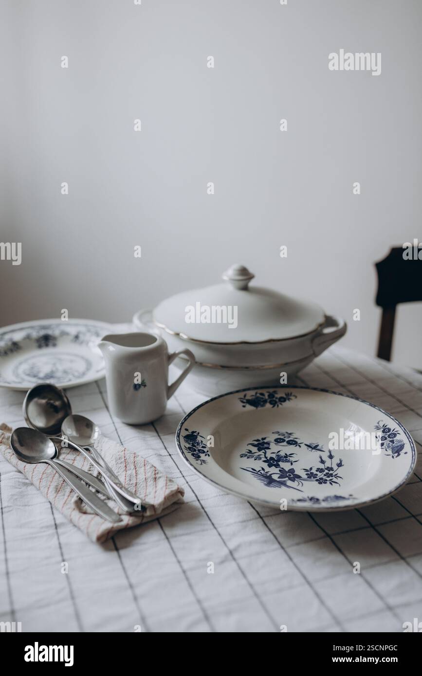 Ein elegant gedeckter Vintage-Esstisch, wunderschön eingerichtet für ein formelles Mittag- oder Abendessen Stockfoto