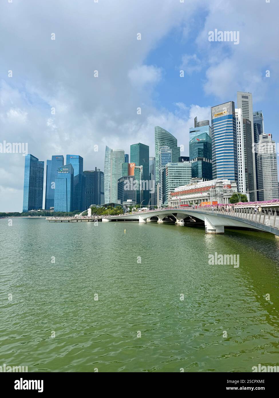 Skyline von Singapur, Menschen auf einer Brücke über dem Wasser. Wunderschöner Tag. - Smartphone-aufgenommenes Stockfoto