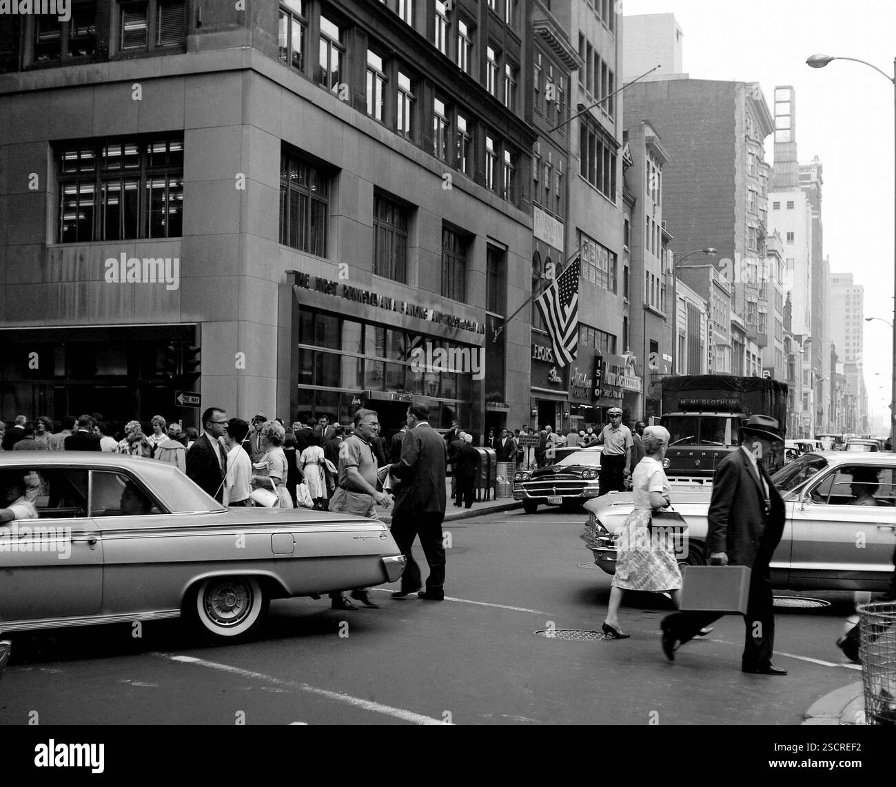 Gebäude (erste Bank- und Treuhandgesellschaft in Pennsylvania), Autos, Passanten und Verkehrspolizisten in der Rush Hour in Philadelphia. [Automatisierte Übersetzung] Stockfoto