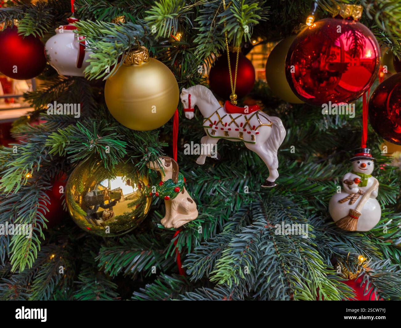 Farbenfrohe Ornamente und festliche Figuren zieren einen Weihnachtsbaum, der die Freude an der Weihnachtszeit einfängt. Stockfoto