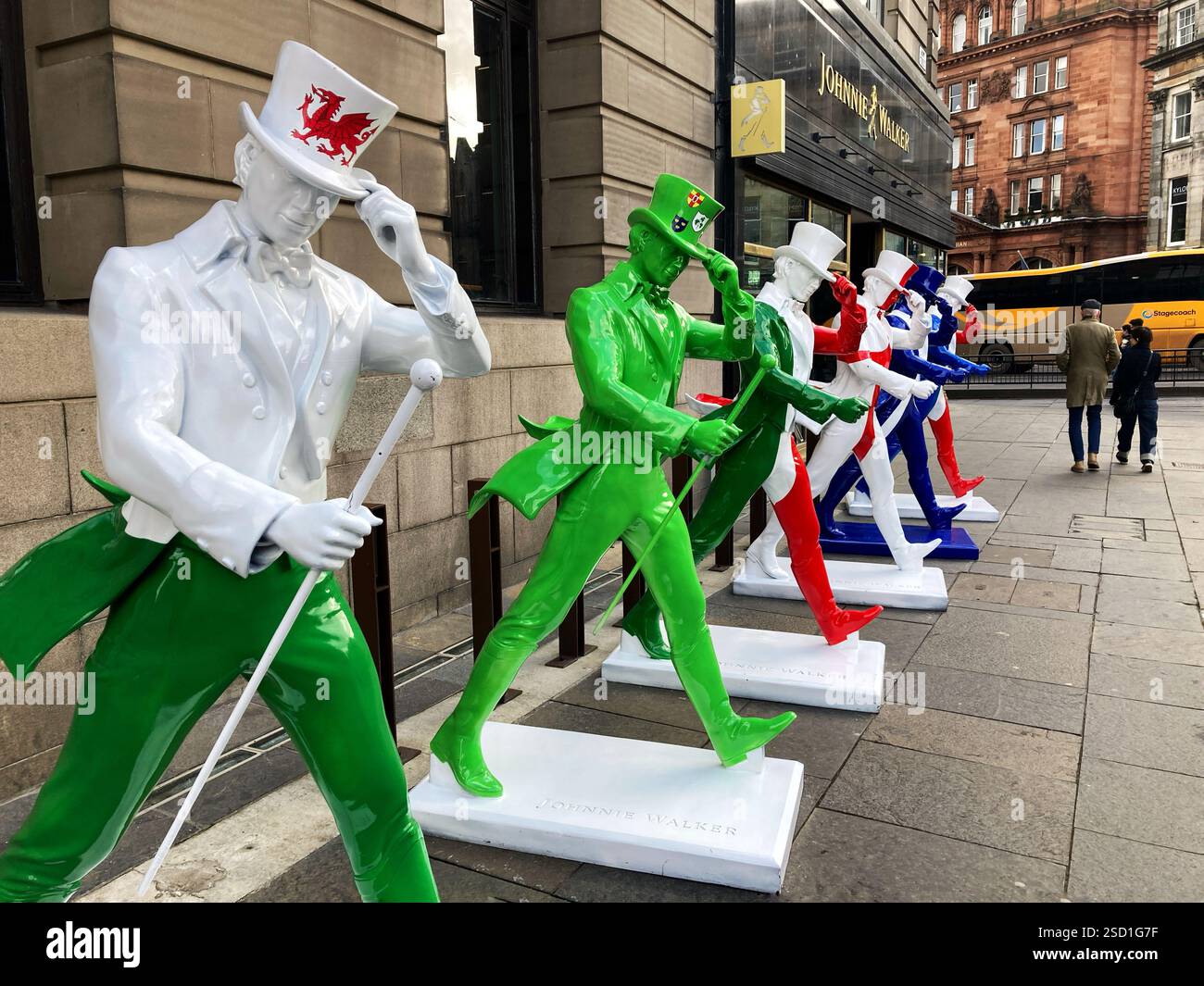Johnnie Walker Whisky Striding man Statuen in Six Nations Rugby Farben außerhalb der Johnnie Walker Experience, Hope Street, Edinburgh Schottland, 2025 Stockfoto