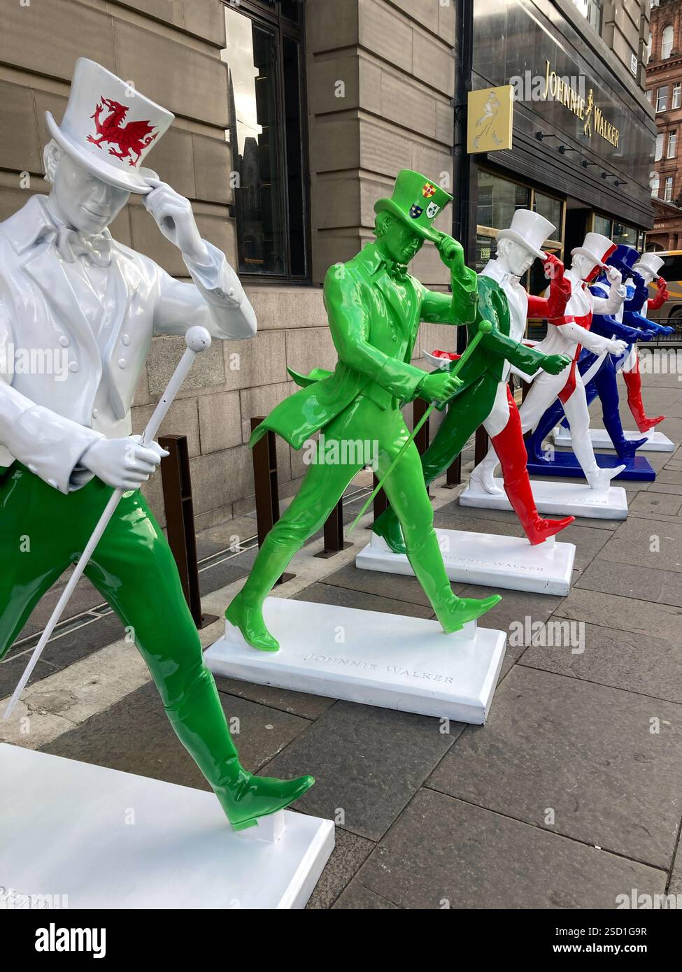 Johnnie Walker Whisky Striding man Statuen in Six Nations Rugby Farben außerhalb der Johnnie Walker Experience, Hope Street, Edinburgh Schottland, 2025 Stockfoto