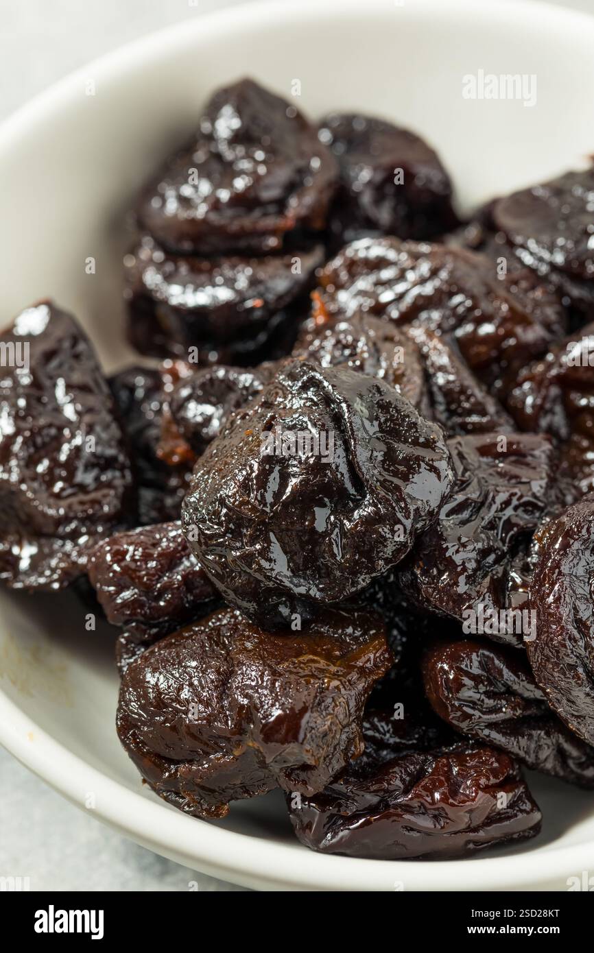 Organische Rohpflaumen in einer Schüssel Stockfoto