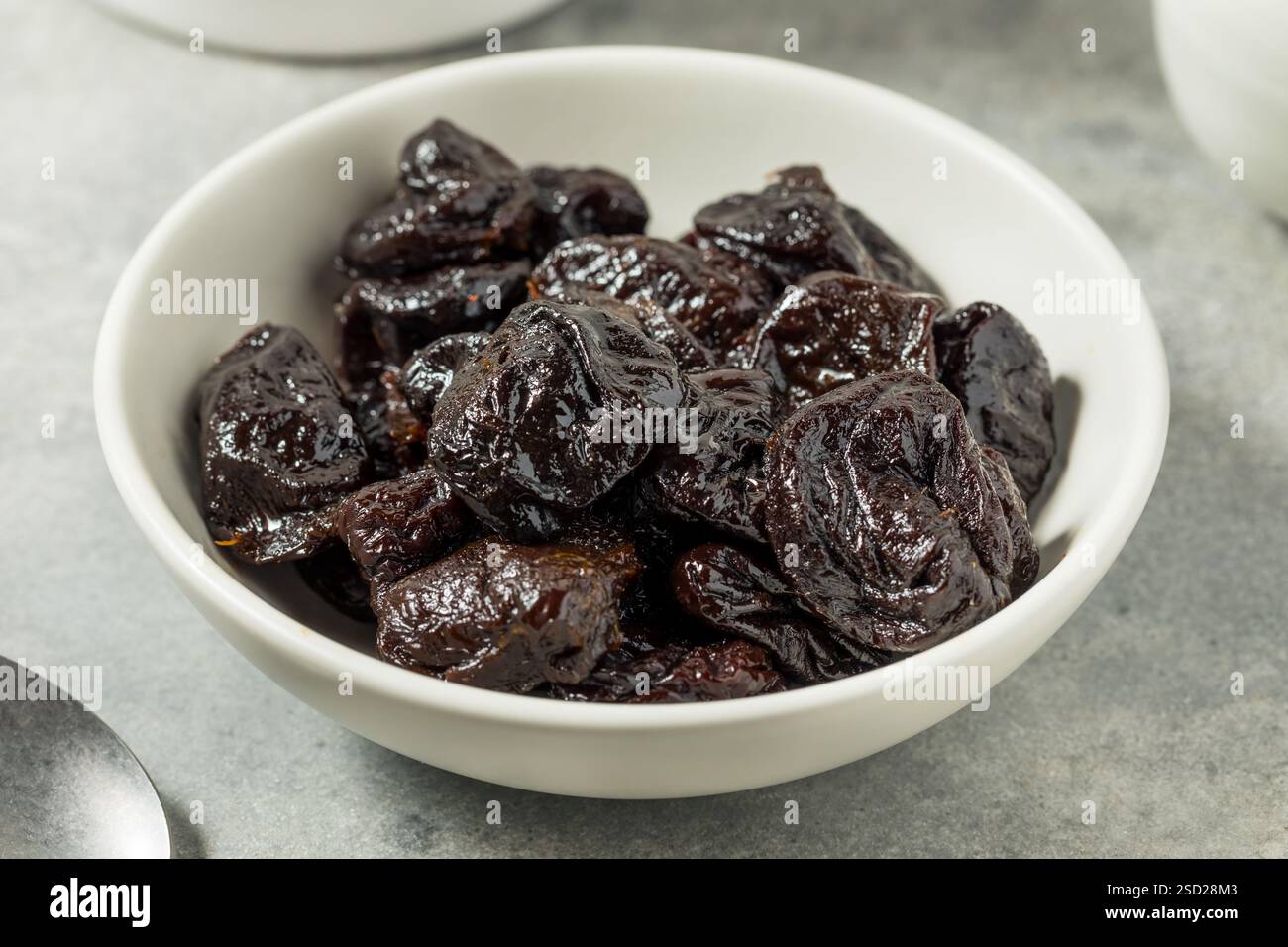 Organische Rohpflaumen in einer Schüssel Stockfoto