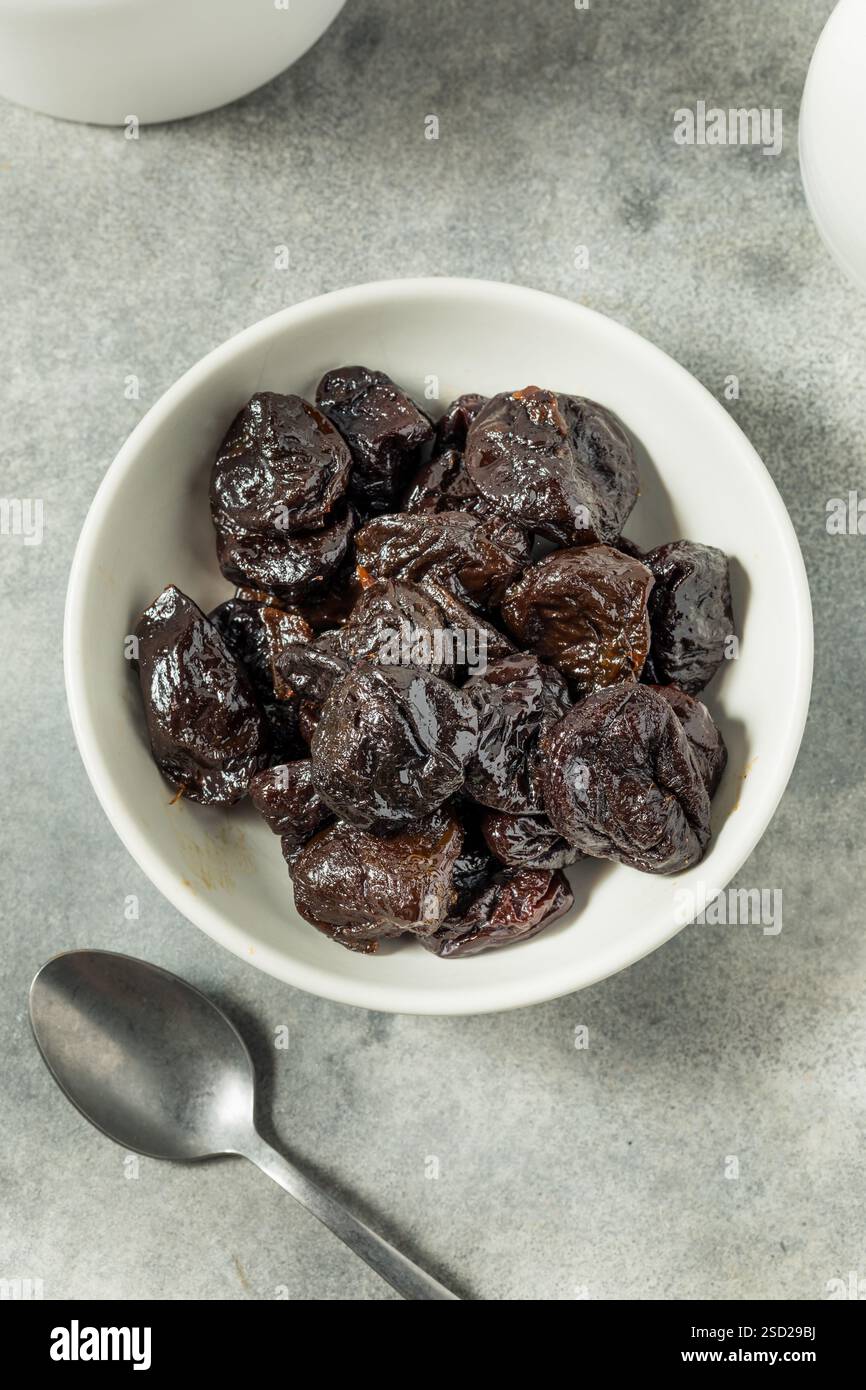 Organische Rohpflaumen in einer Schüssel Stockfoto