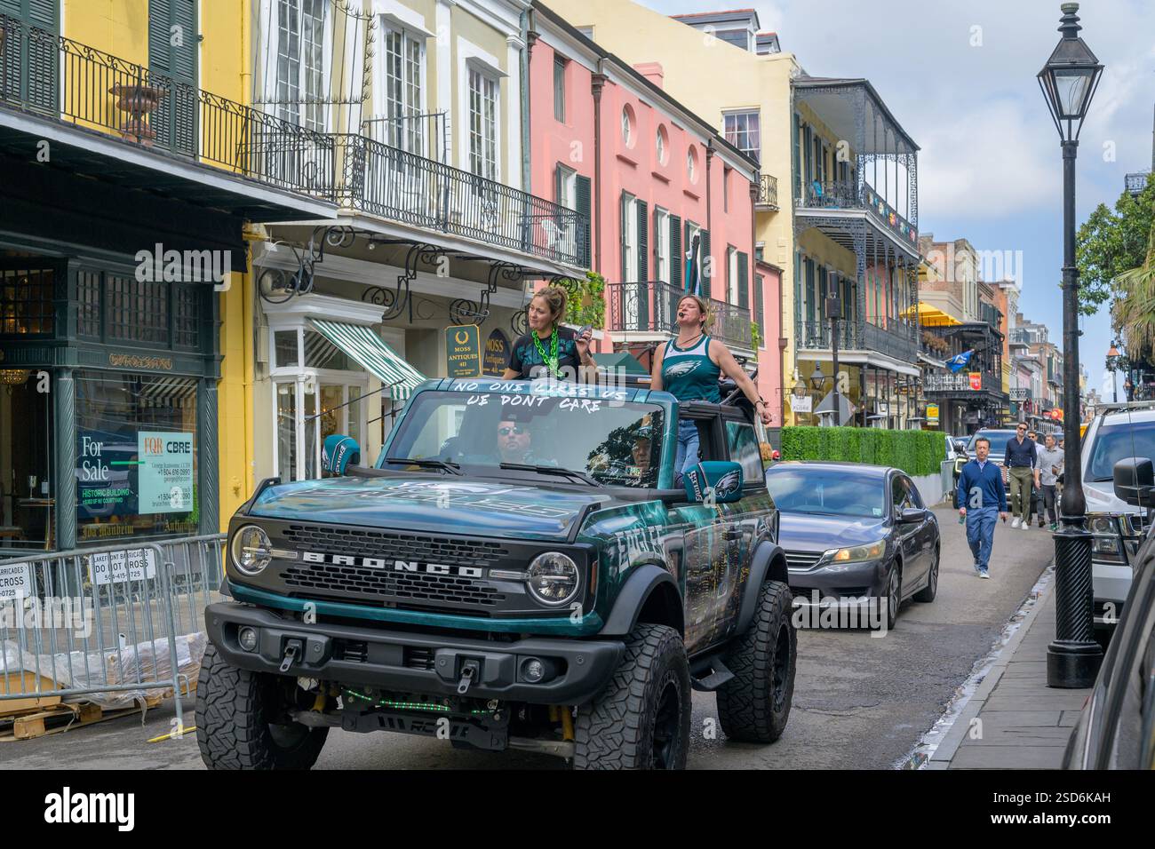 New Orleans, LA, USA – 7. Februar 2025: Die Fans der Philadelphia Eagles Rollen die Royal Street im French Quarter entlang, um ihre Präsenz bekannt zu machen. Zwei Männer fahren im Taxi, während die Frau über das Dach steigt und Lärm macht. Die Nachricht auf der Windschutzscheibe lautet: „Niemand mag uns; uns ist es egal.“ Die Bronco ist mit dem Eagles Logo und in Eagles Green dekoriert. Der New Orleans Super Bowl LIX ist zwei Tage entfernt. Stockfoto