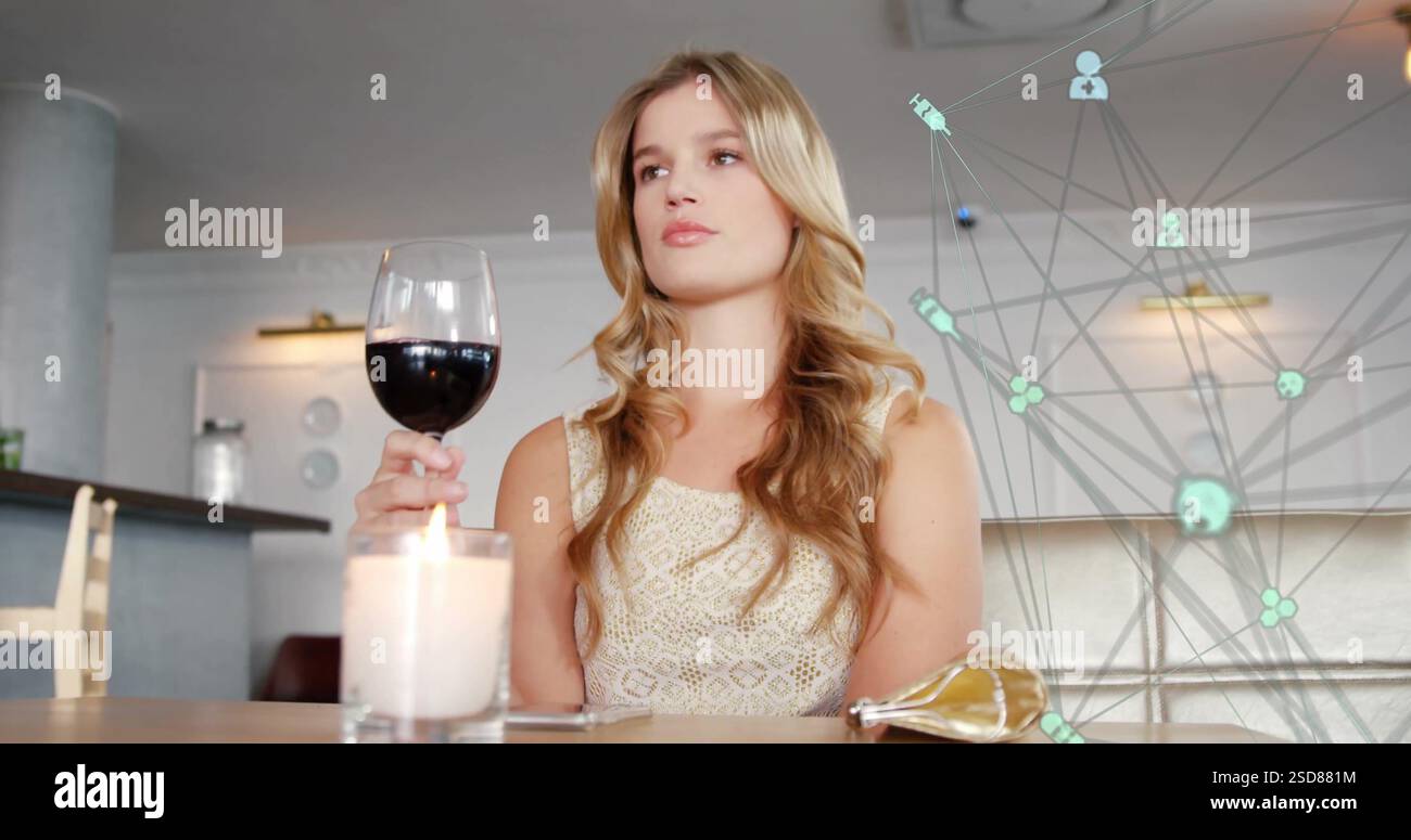 Frau genießt ein Glas Rotwein in einem eleganten Restaurant und sieht nachdenklich aus Stockfoto