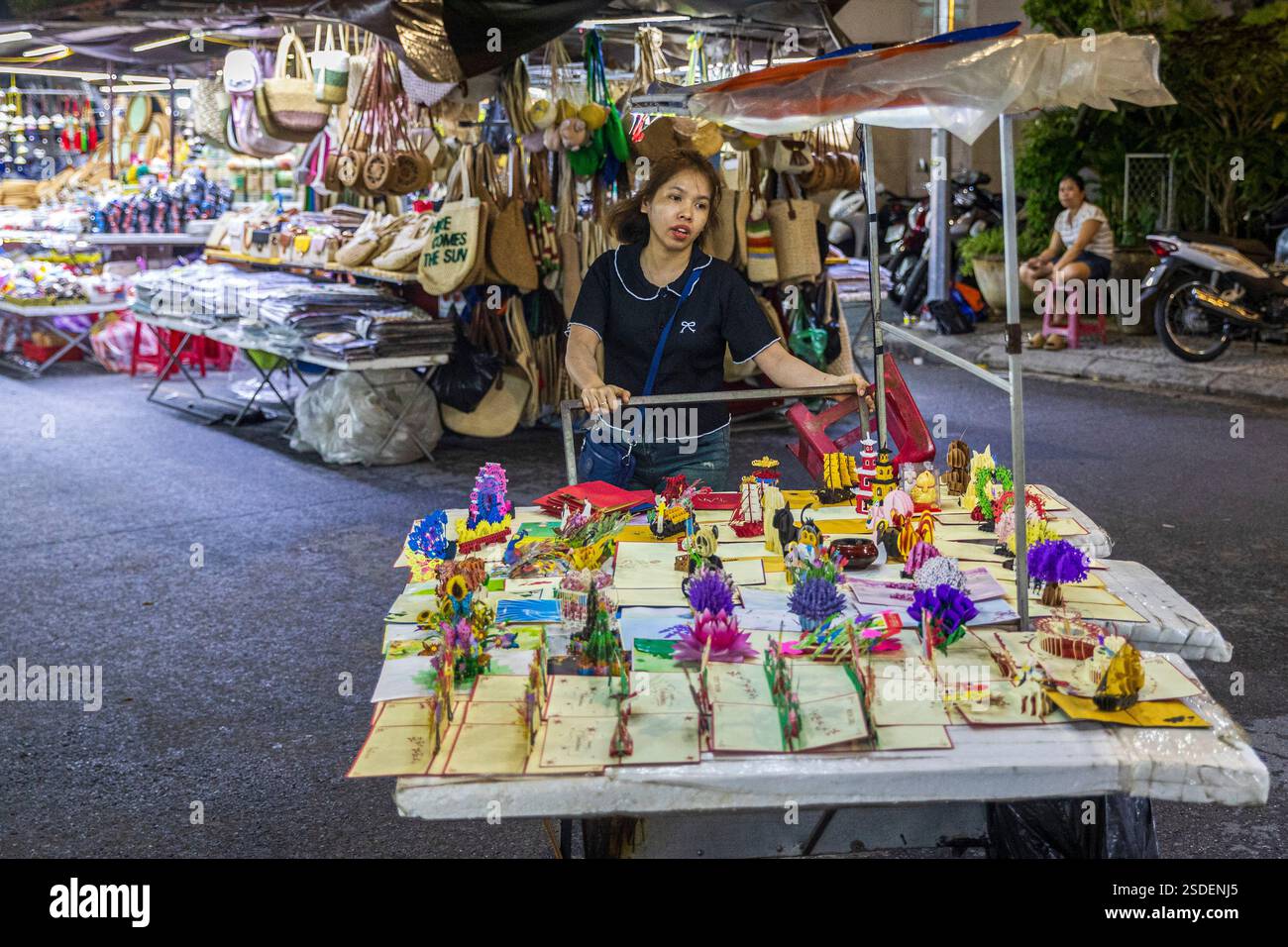 Ein lokaler Anbieter stellt handgefertigtes Kunsthandwerk auf einem Nachtmarkt vor, der von Ständen umgeben ist, und zwar am Mittwoch, den 06. November 2024. Stockfoto