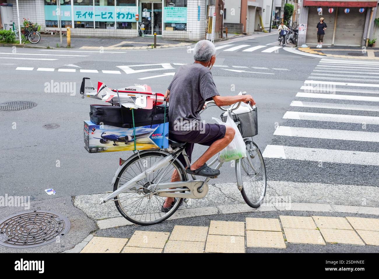 Ein älterer Mann auf dem Fahrrad in Japan. Stockfoto