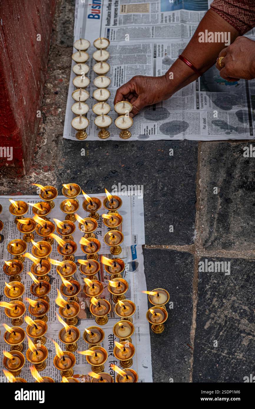 Im ruhigen Herzen von Boudhanath, Kathmandu, setzt eine Person sorgfältig Kerzen in ordentliche Reihen. Stockfoto