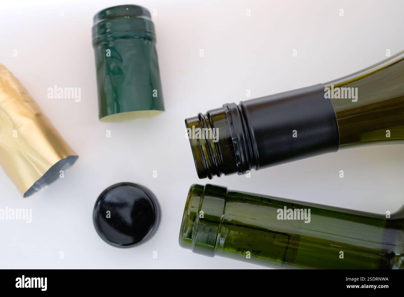 Wein-Engpass mit Schraubverschluss. Flasche mit Korken. Verschlüsse aus Flaschenfolie in verschiedenen Farben. Verschiedene Arten von Weinkorken. Stockfoto