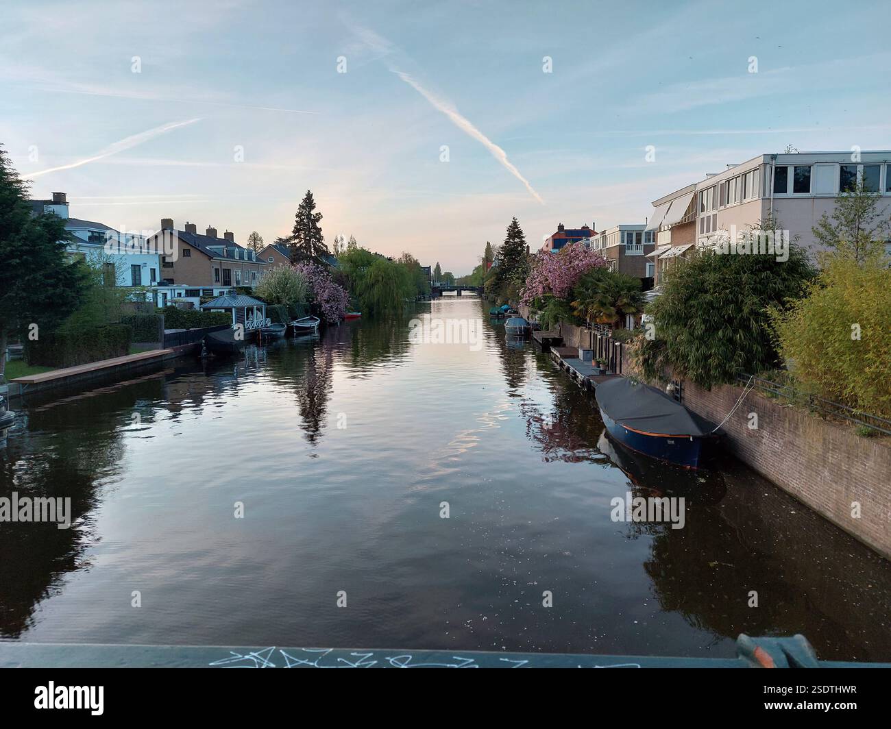 Blick auf einen Wasserweg mit blühenden Bäumen und Booten auf beiden Seiten, nahe Amstedam im Frühjahr 2022 Stockfoto