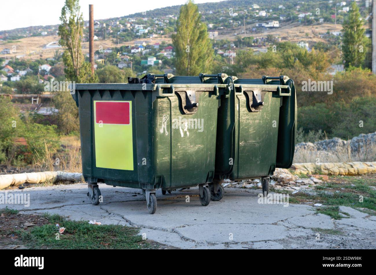 Müllcontainer, die entlang einer Straße in der städtischen Umwelt platziert werden Stockfoto