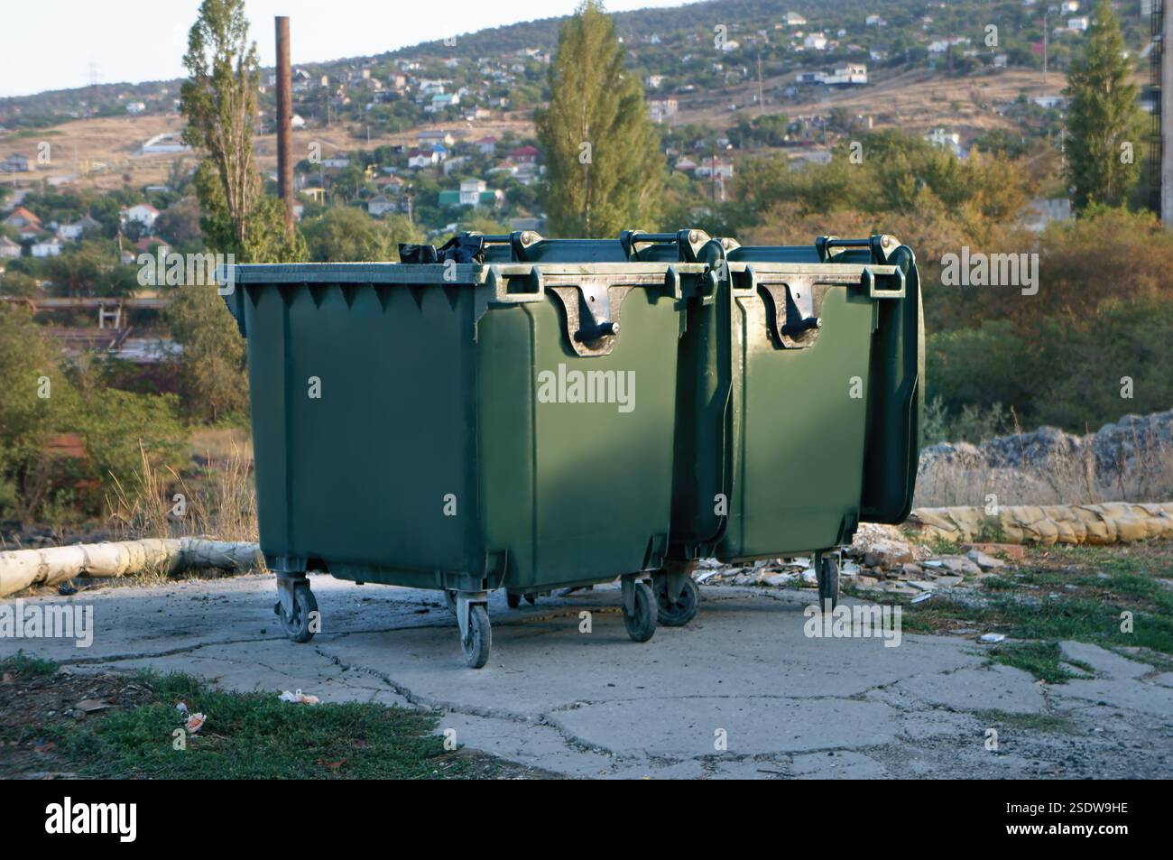 Müllcontainer, die entlang einer Straße in der städtischen Umwelt platziert werden Stockfoto