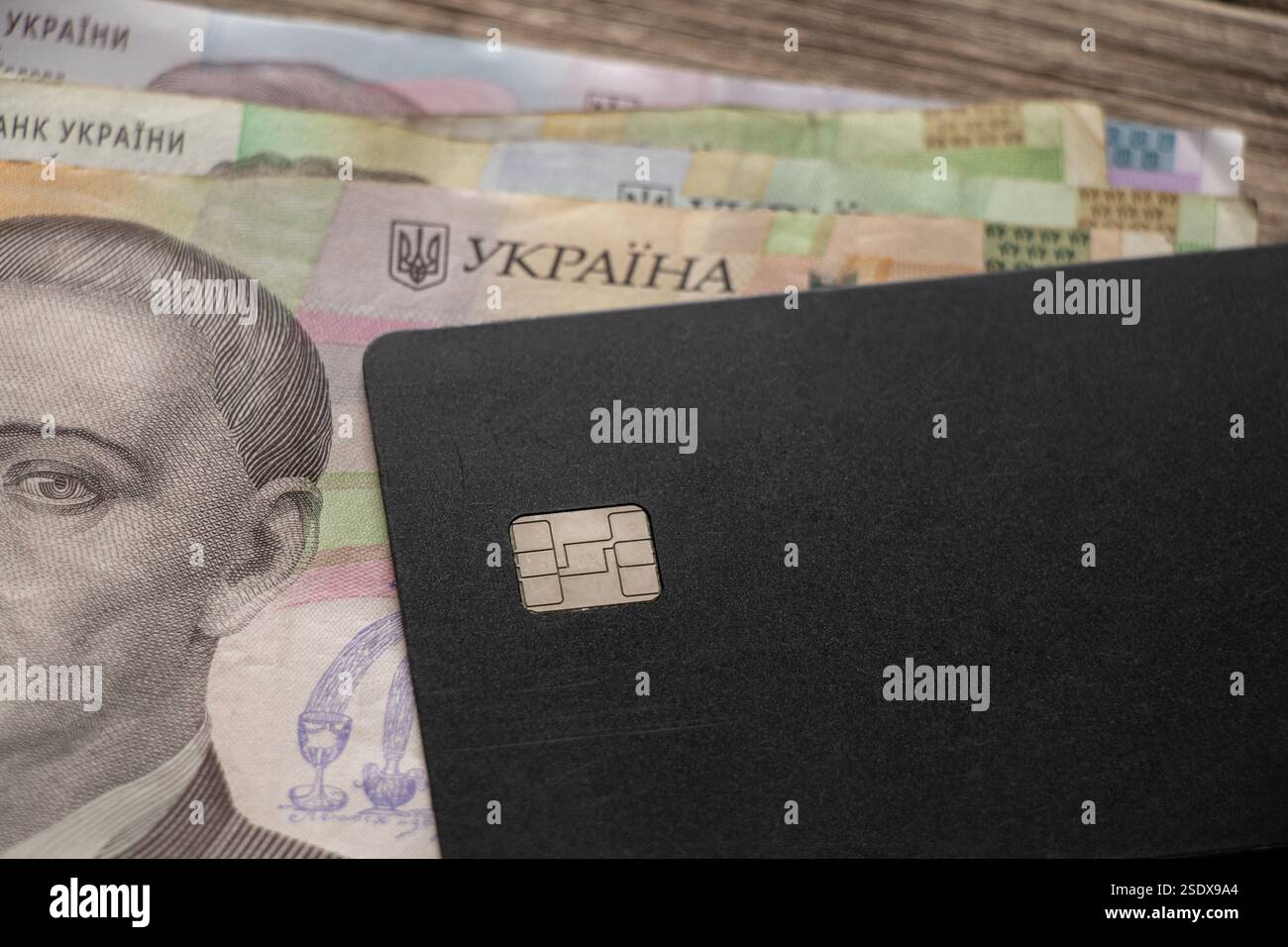 Ukrainische Griwna und schwarze Kreditkarte Nahaufnahme, Geld und Kreditkarte Stockfoto