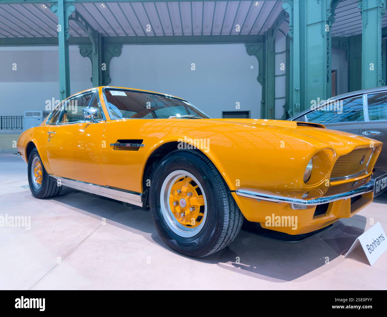 Oldtimer-Sportwagen in Orange in einer modernen Ausstellungshalle Stockfoto