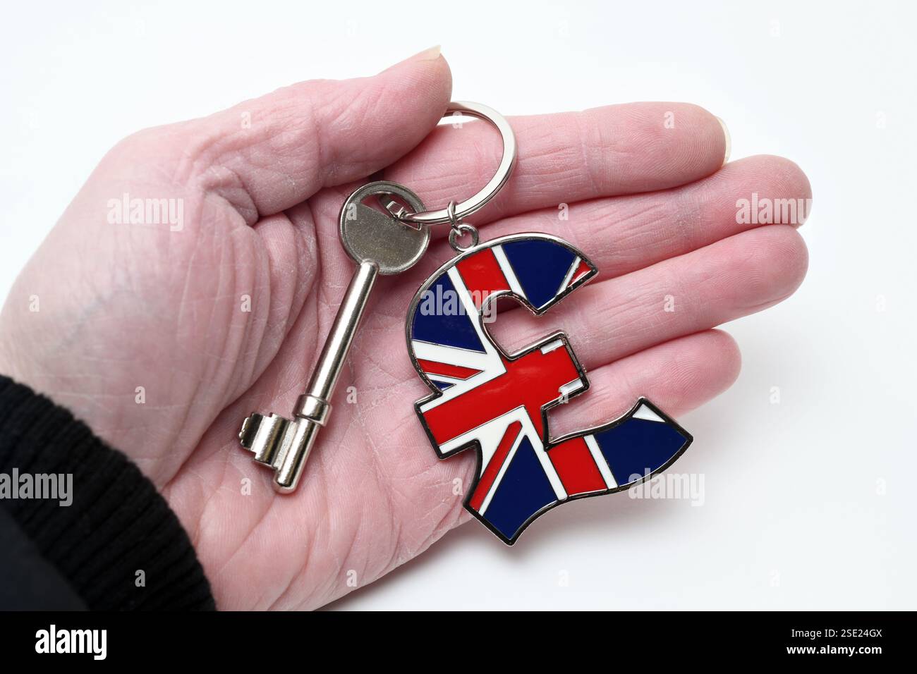 HAUSSCHLÜSSEL UND SCHLÜSSELANHÄNGER AUF MANS HAND RE HAUS KAUFEN HYPOTHEKEN HAUSBESITZ USW. GROSSBRITANNIEN Stockfoto