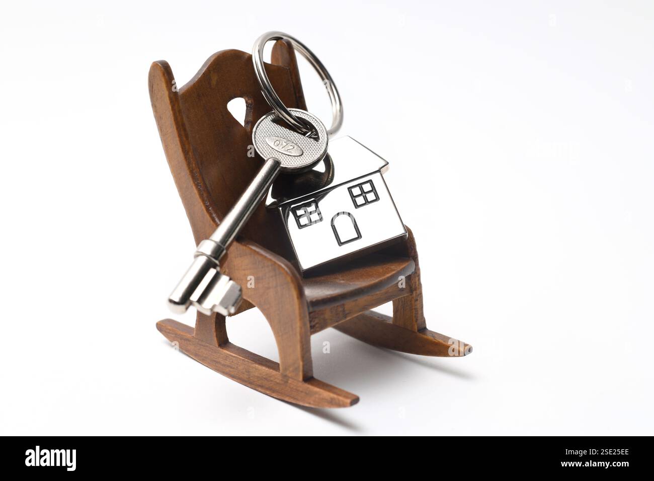 HAUSSCHLÜSSEL UND SCHLÜSSELANHÄNGER AUF SCHAUKELSTUHL RE HAUS KAUFEN HYPOTHEKEN HAUSBESITZ USW. GROSSBRITANNIEN Stockfoto