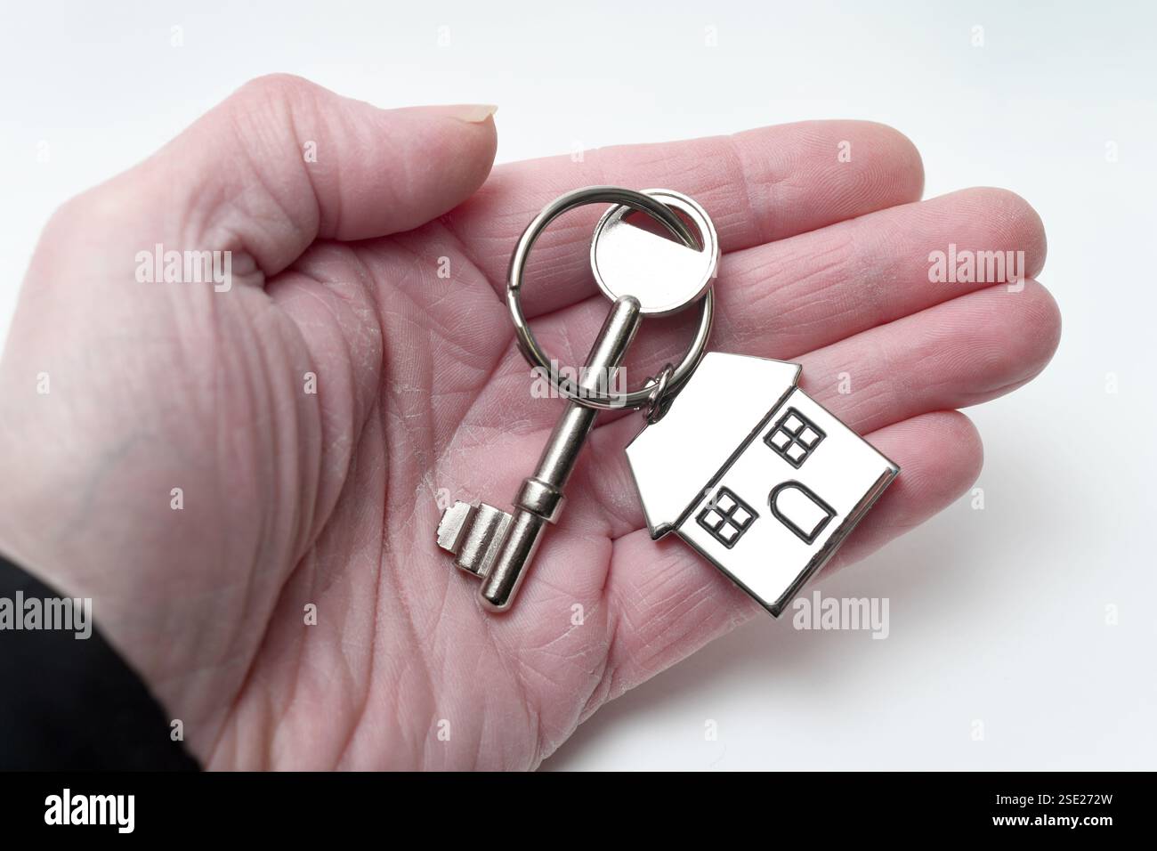 HAUSSCHLÜSSEL UND SCHLÜSSELANHÄNGER AUF MANS HAND RE HAUS KAUFEN HYPOTHEKEN HAUSBESITZ USW. GROSSBRITANNIEN Stockfoto