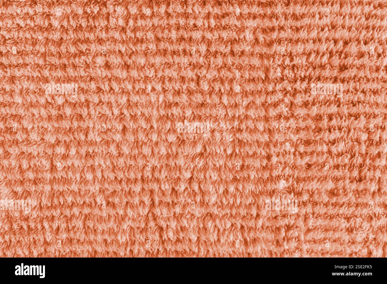Frotteetuch, gestreiftes Muster orange Handtuch Textur Hintergrund. Weiches flauschiges Textilbad oder Mikrofaser Strandtuch Material. Draufsicht, Nahaufnahme, Makro. Stockfoto