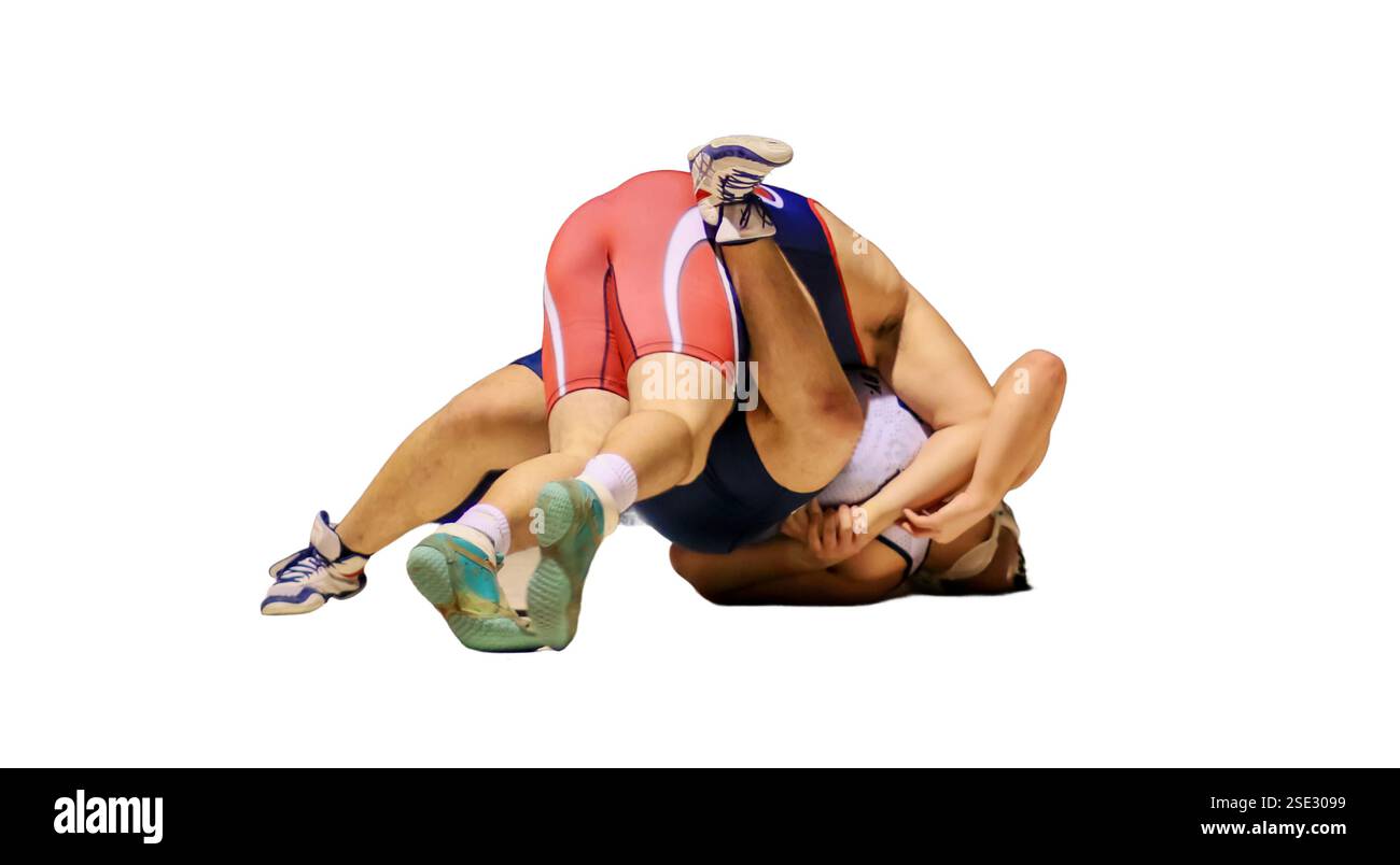 Zwei Wrestler greifen sich während eines Wettkampfes in einem High School Gym unter einem Scheinwerfer mit weißem Hintergrund an die Matte. Stockfoto