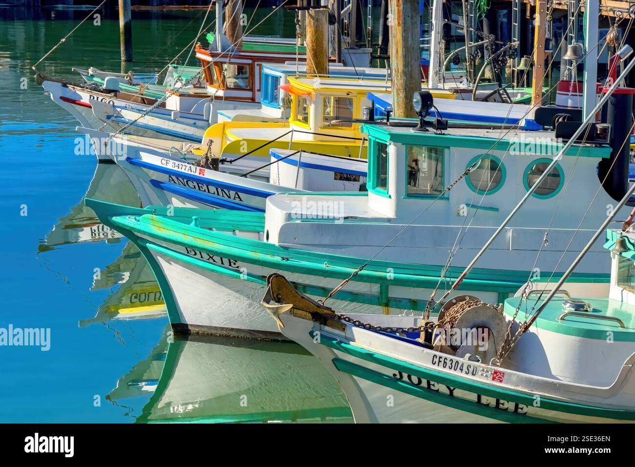 An Fisherman's Wharf in San Francisco liegen farbenfrohe Fischerboote, die sich vom ruhigen Wasser spiegeln. Jedes Boot bietet verschiedene Kombinationen o Stockfoto