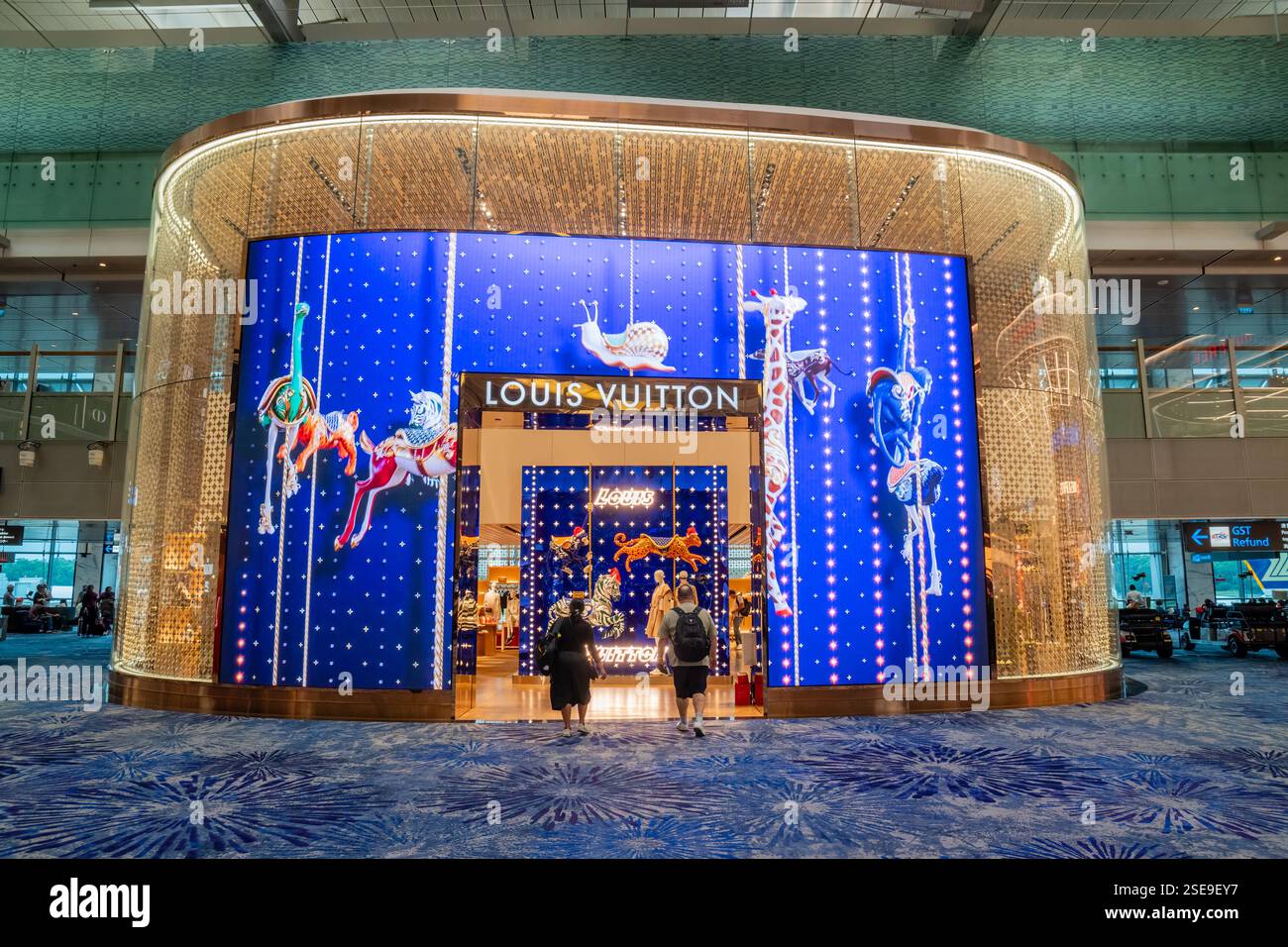 Zwei Personen betreten ein Louis Vuitton Geschäft am Flughafen Changi, Singapur Stockfoto