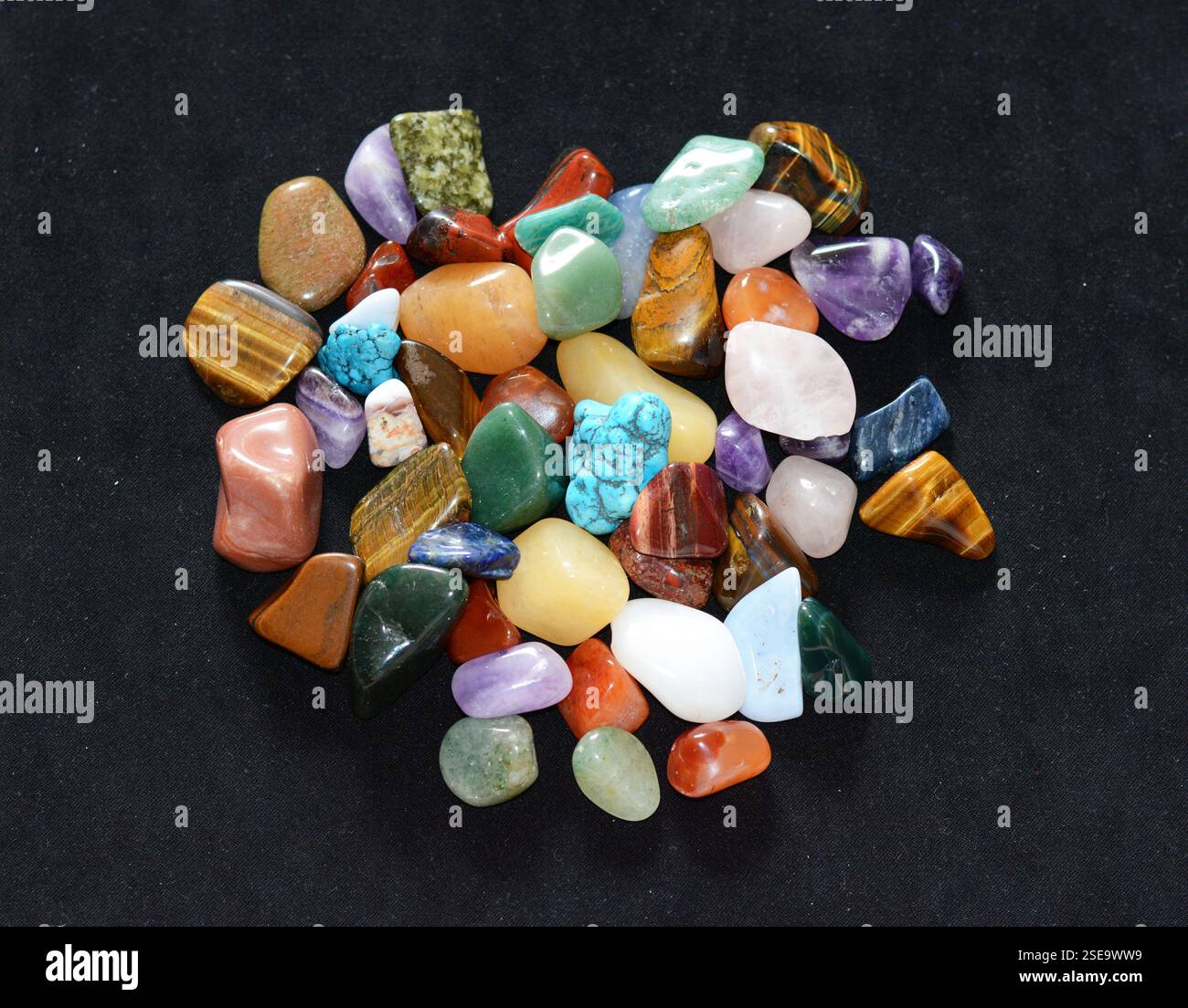 Sammlung verschiedener roher Edelsteine wie Tigerauge, Amethyst, Zitrin, Quarz, jaspis, die natürliche Schönheit und Energie des Heilsteins zeigen Stockfoto