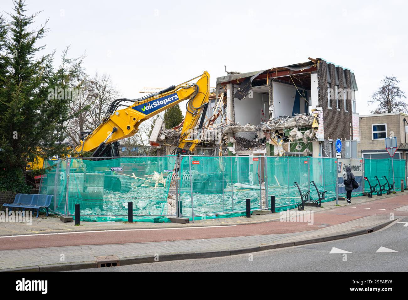 Das alte Gebäude wird mit einer großen Maschine abgerissen Stockfoto