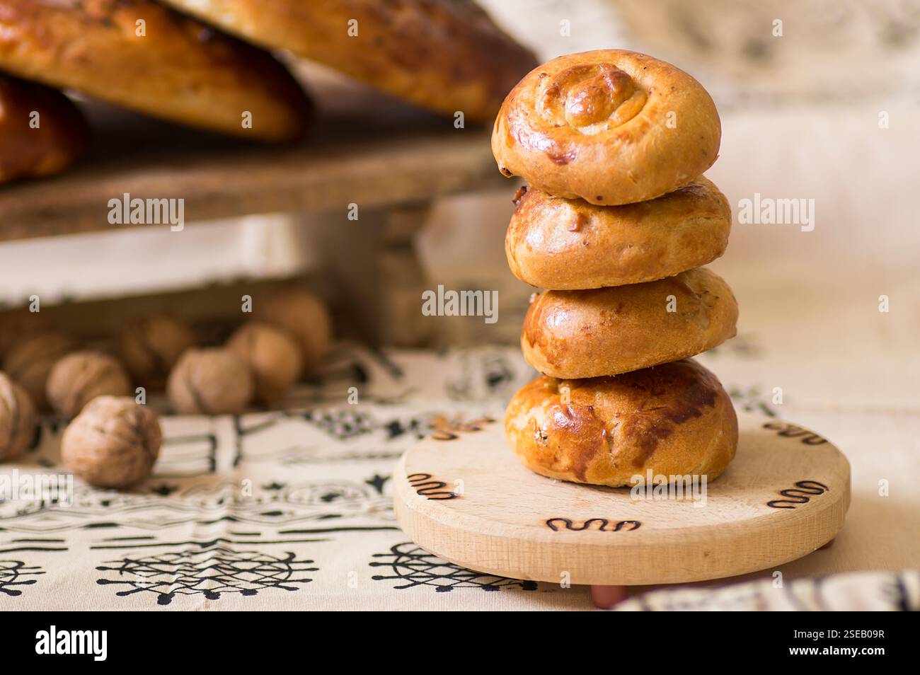 Türkisches Gebäck, Scone oder Brötchen mit Walnuss auf traditionellem Tokat-Tischtuch, hausgemachtes Gebäck-Konzept Stockfoto