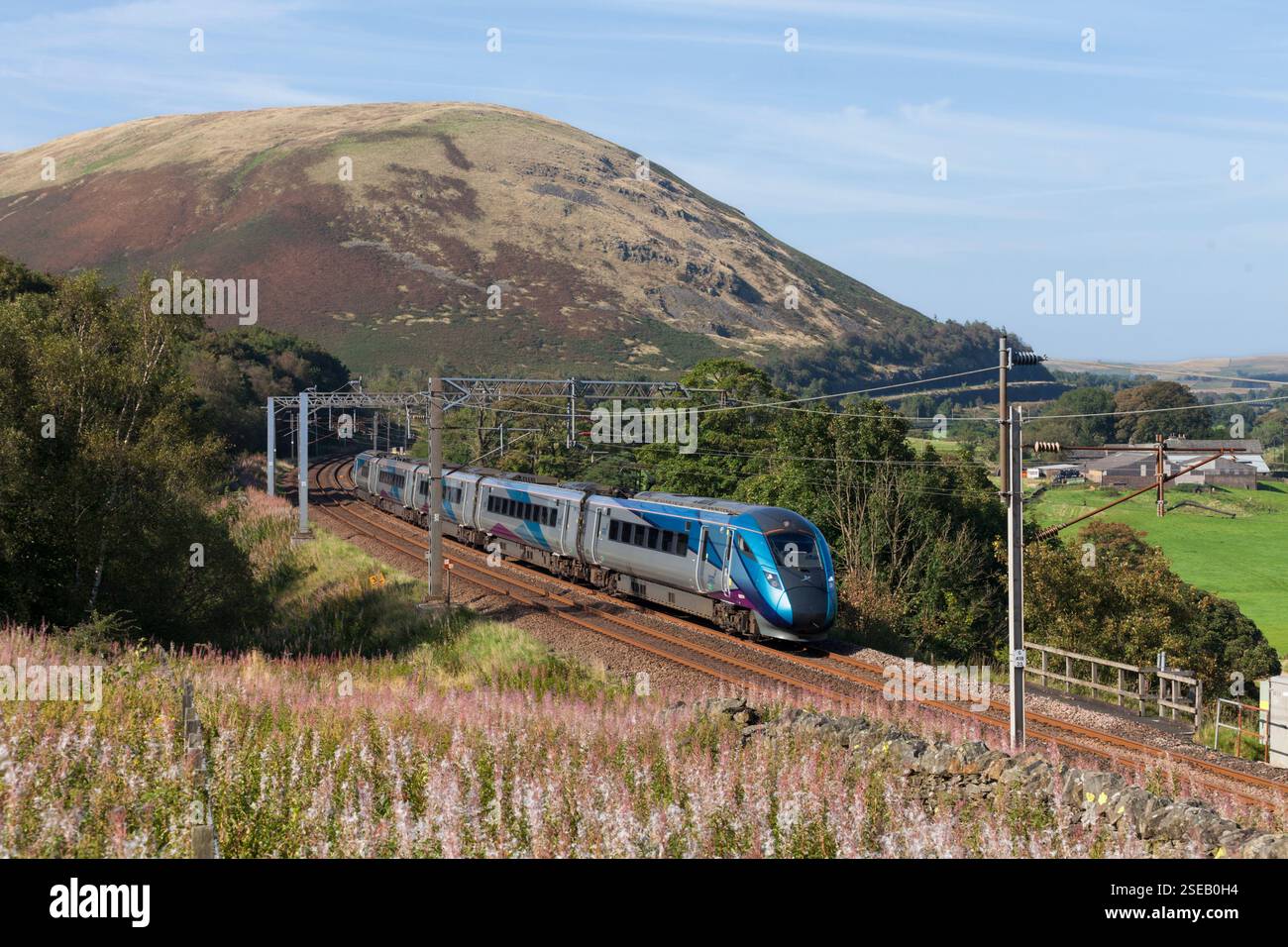 TransPennine Express-Zug der Baureihe 802 Hitachi AT300 im BI-Modus, der durch die Landschaft in Cumbria auf der Hauptstrecke der Westküste fährt Stockfoto