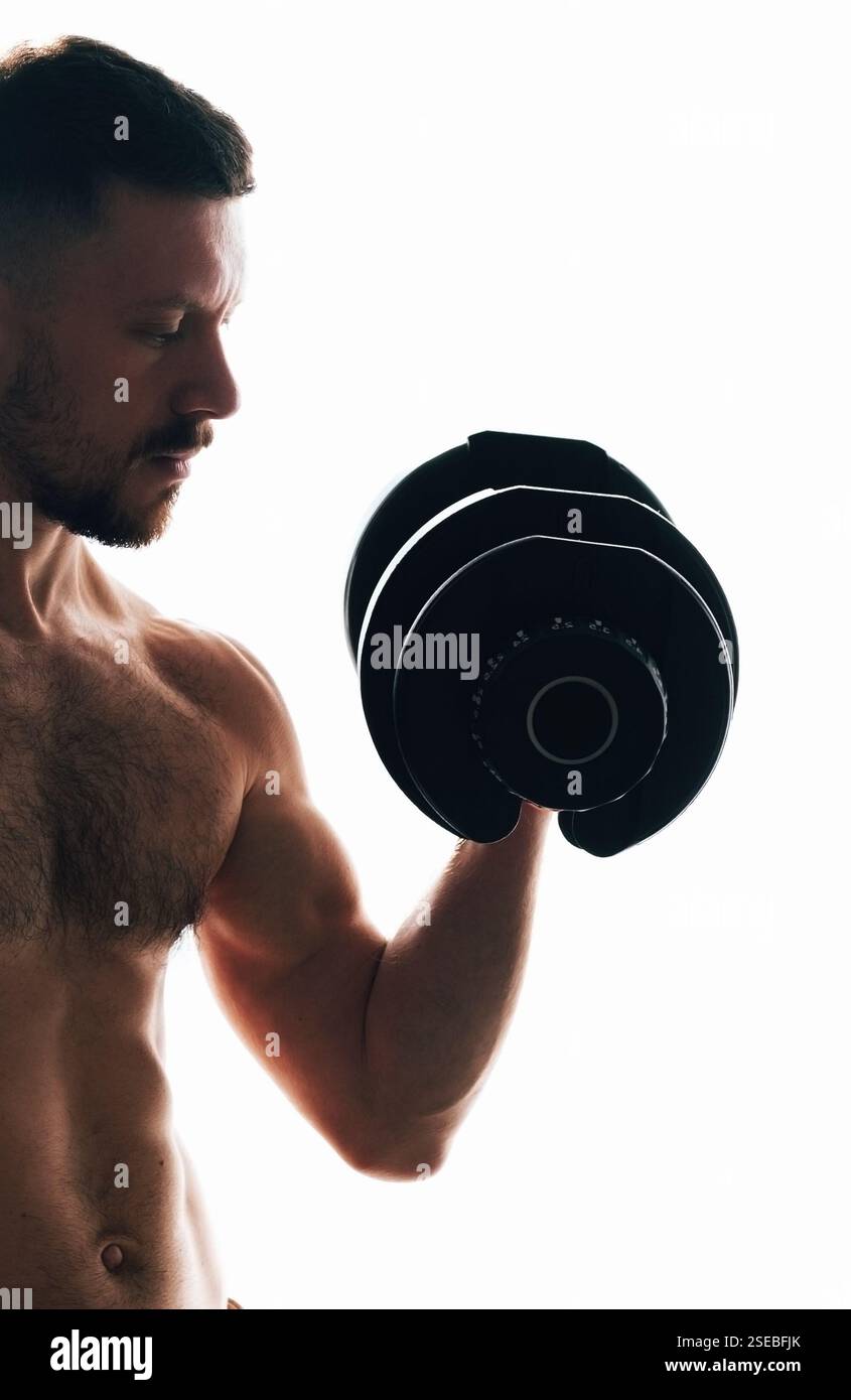 Muskulöser Mann und eine große Hantel. Stockfoto