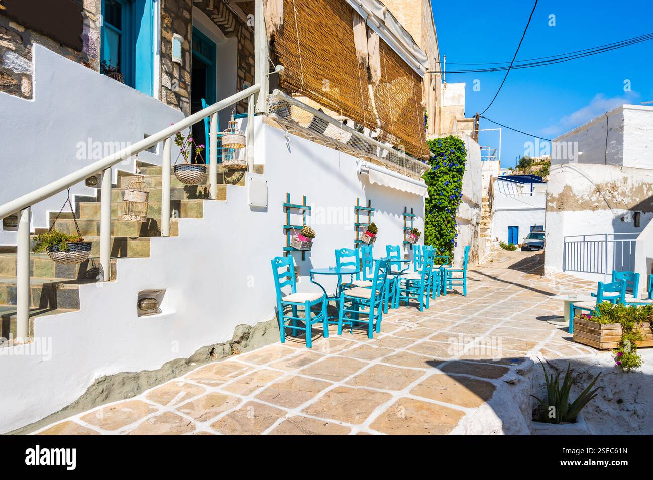 Taverne in einer engen Straße mit typisch griechischer Architektur in Kimolos Dorf, Kimolos Insel, Kykladen, Griechenland Stockfoto
