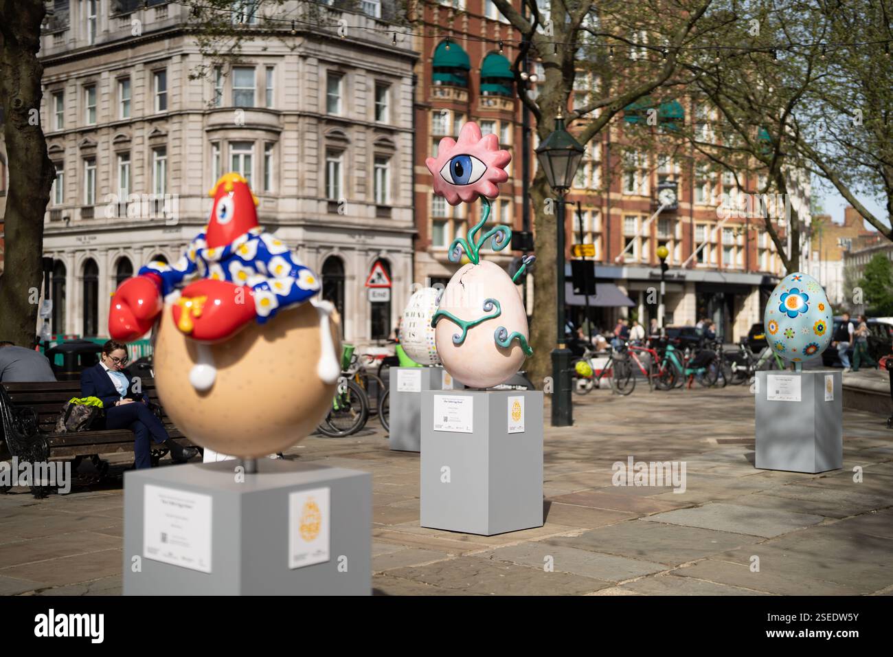Farbenfrohe Eierskulpturen, die Teil von „The Little Egg Hunt“ sind, sind auf Sockeln am Sloane Square, London, ausgestellt. Stockfoto