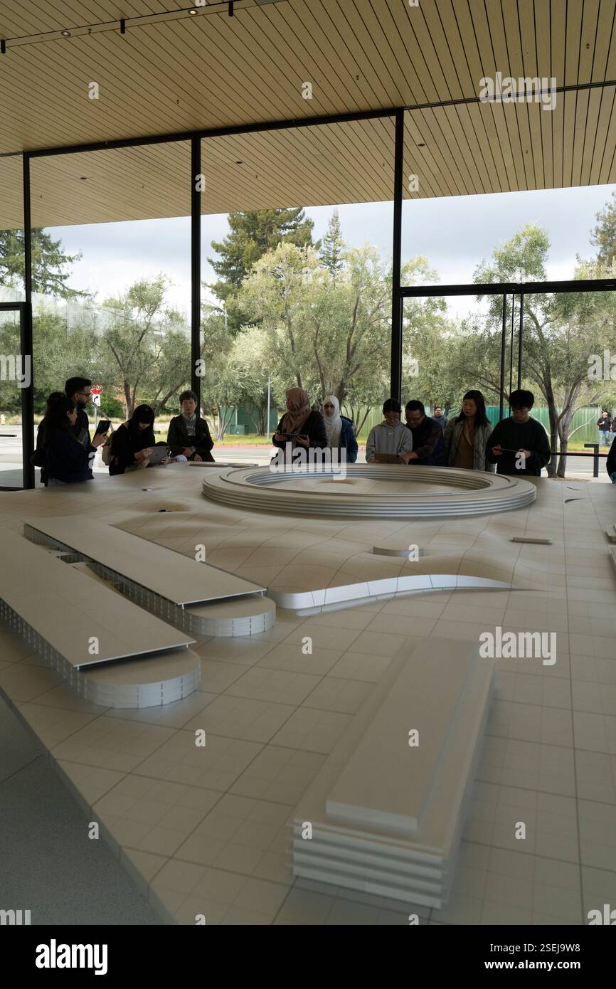 Die Besucher des Steve Jobs Theaters im Apple Park untersuchen ein Modell der neuen Campus-Erweiterung. Stockfoto