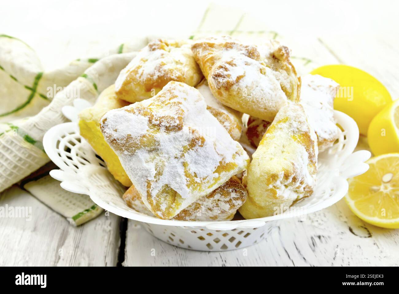 Cookies Zitronensaft in eine Schüssel geben, Serviette, Zitronen auf dem Hintergrund Licht Holzbrettern Stockfoto